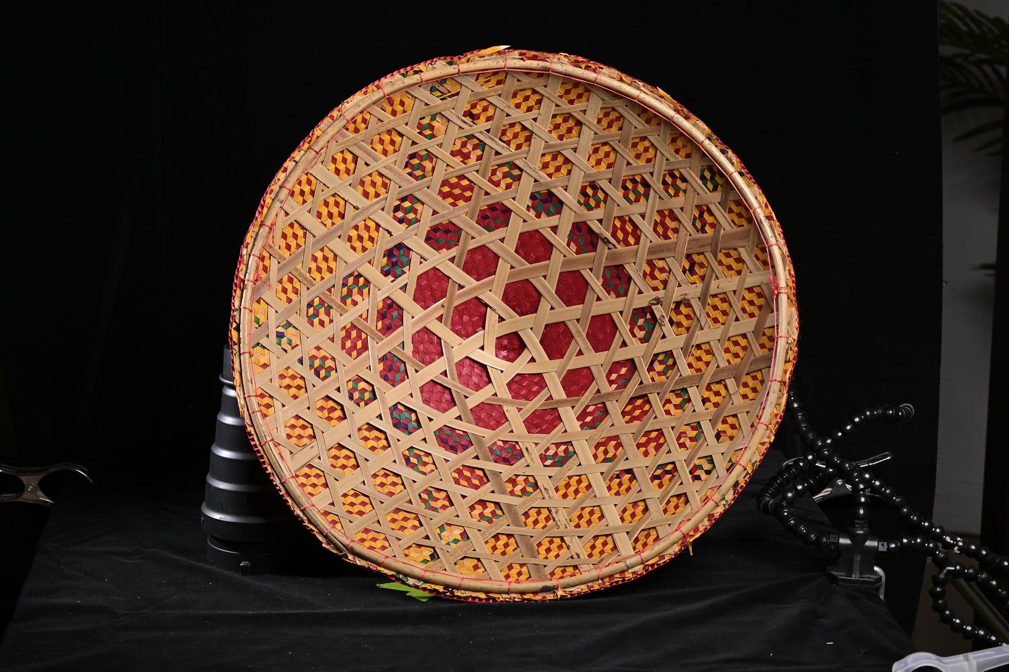 Hand-woven tray photographed on black for a product catalog