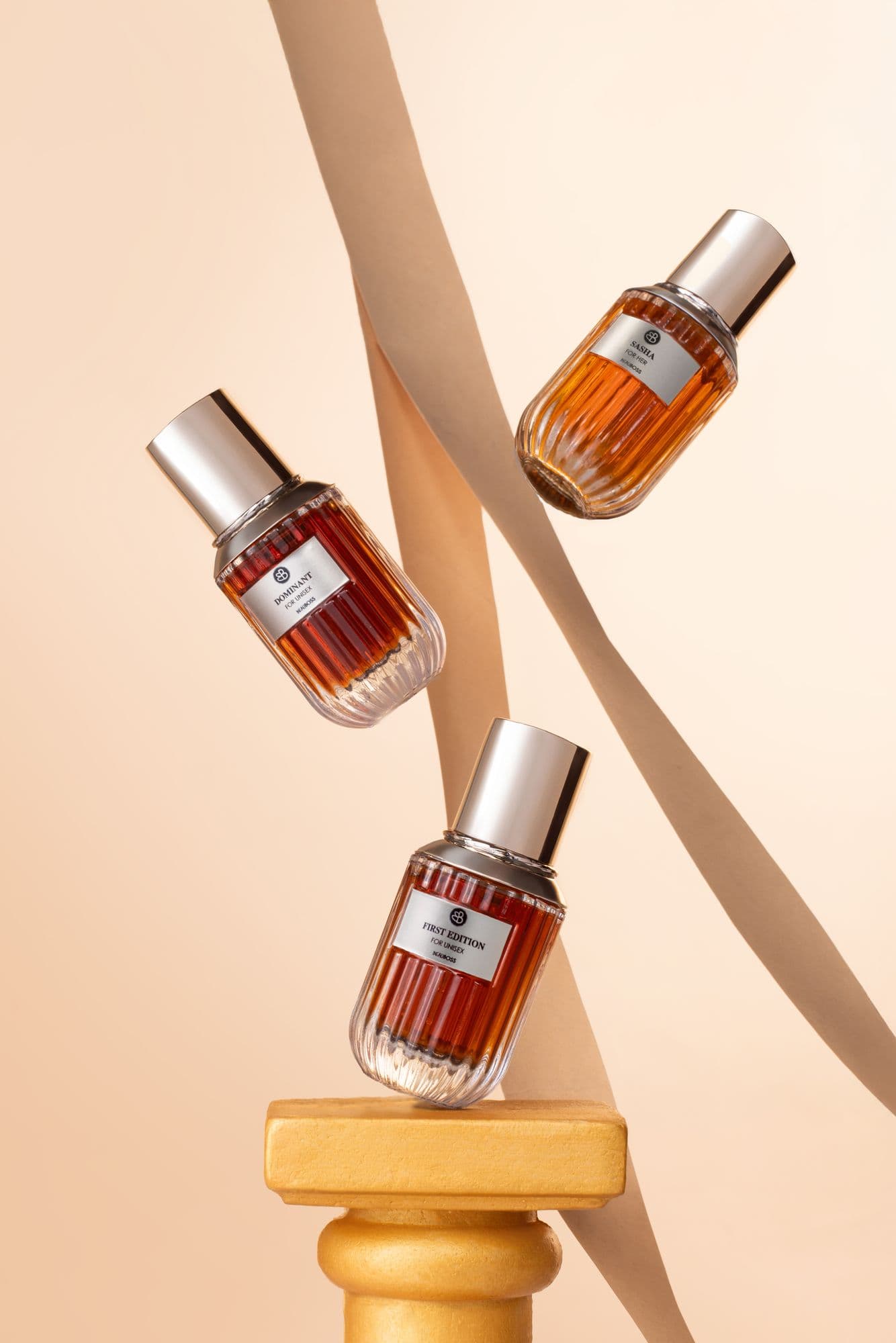 Beauboss perfume bottles floating against a peach backdrop