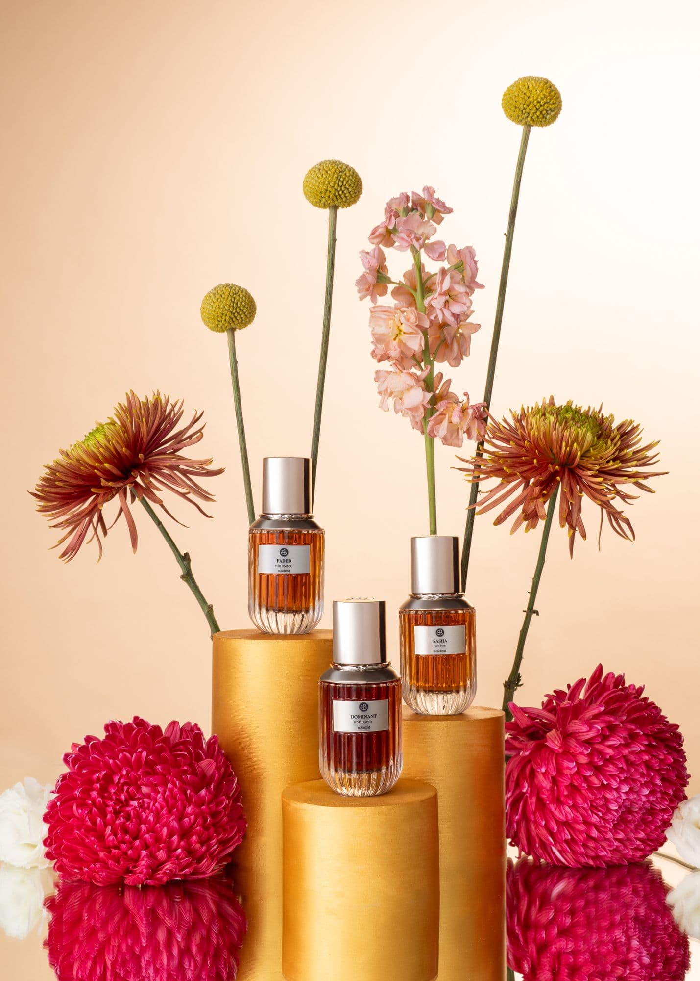 Beauboss perfume bottles on gold pedestals with dried florals