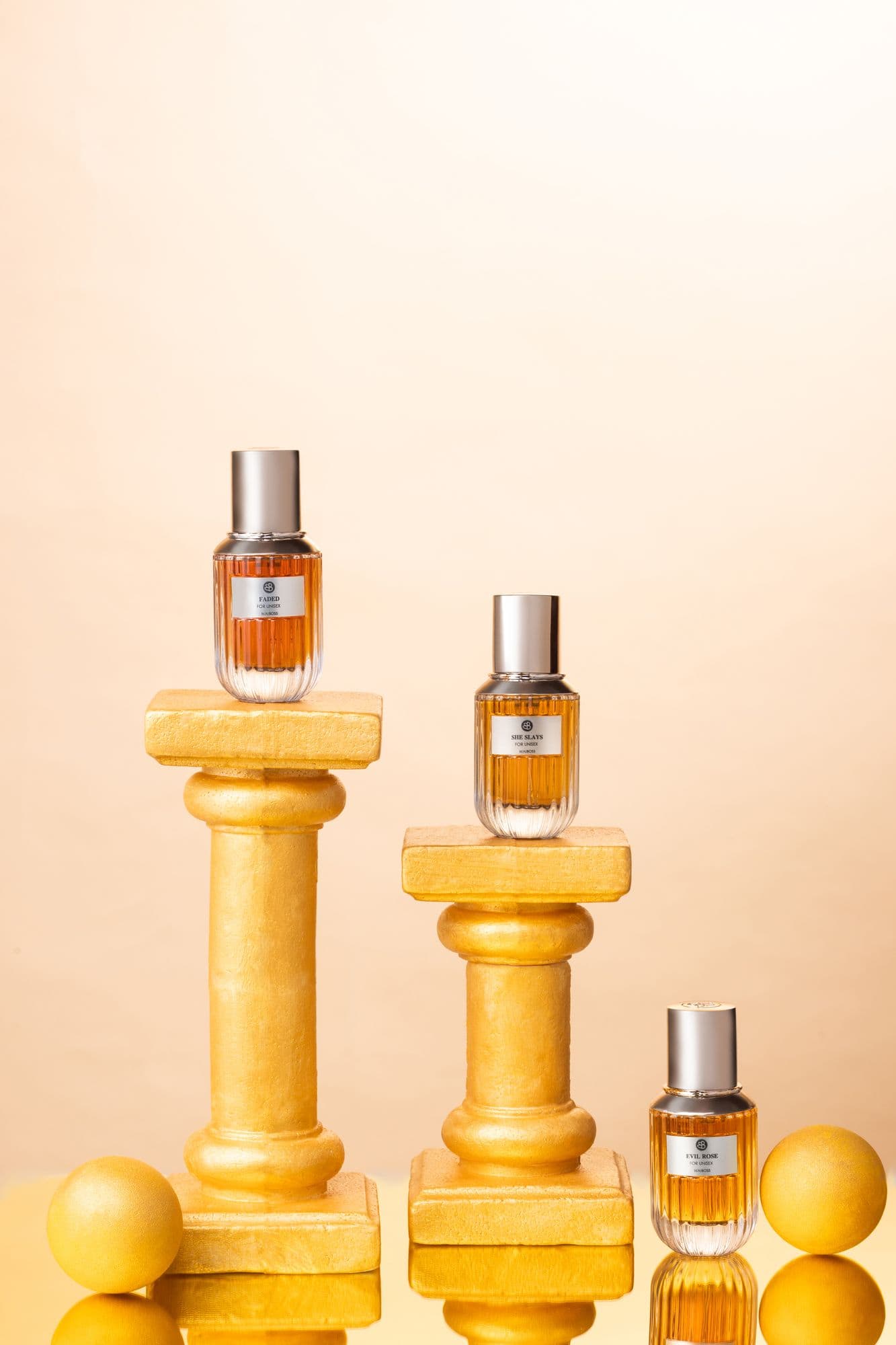 Beauboss perfume bottles arranged on gold columns and spheres