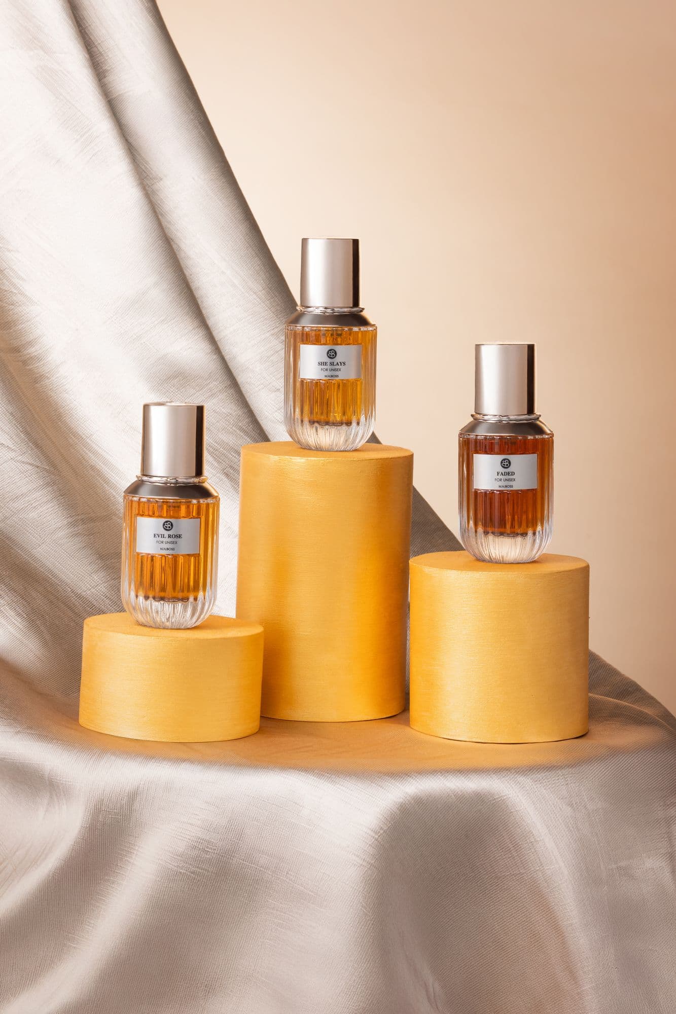 Beauboss perfume bottles on gold cylinders with satin drapery